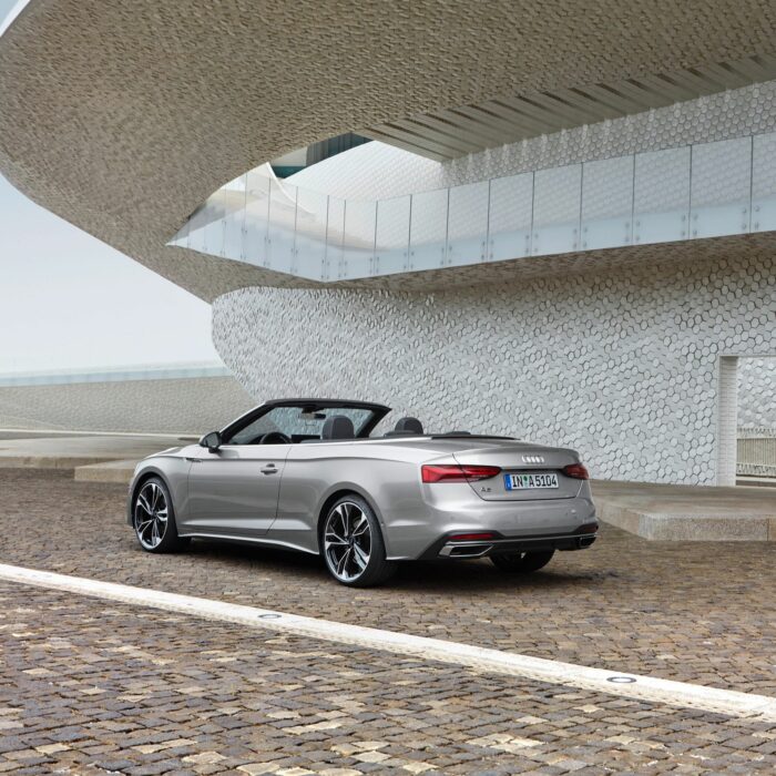 Cabriolet de dos garé devant batiment