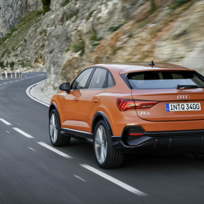 Location Audi Q3 Sportback sur route vu de dos