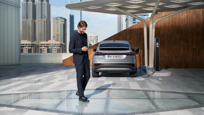 homme derrière voiture location audi qui charge