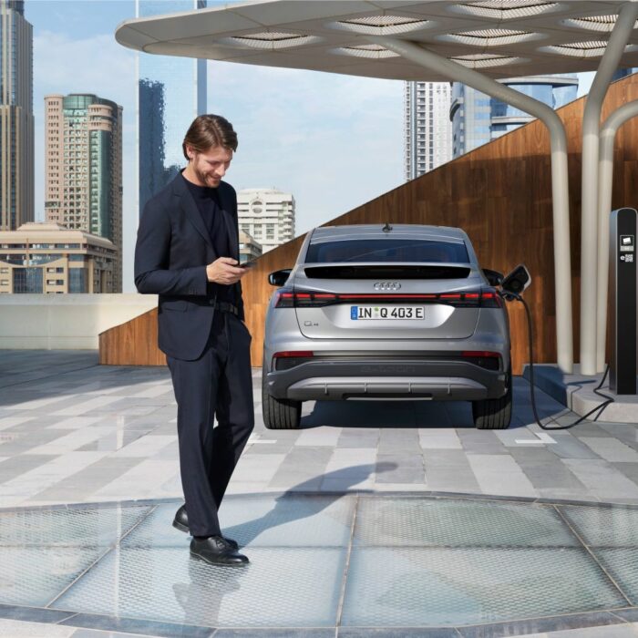 homme derrière voiture location audi qui charge