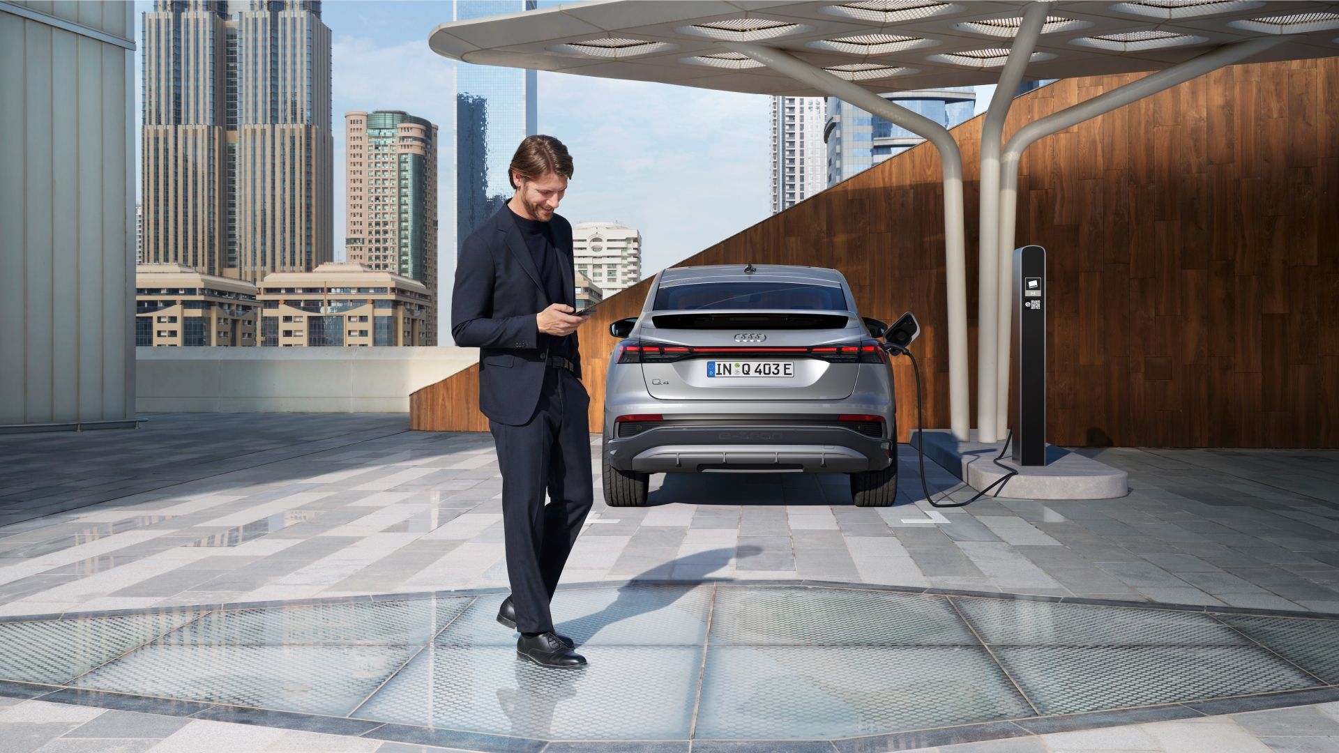 homme derrière voiture location audi qui charge